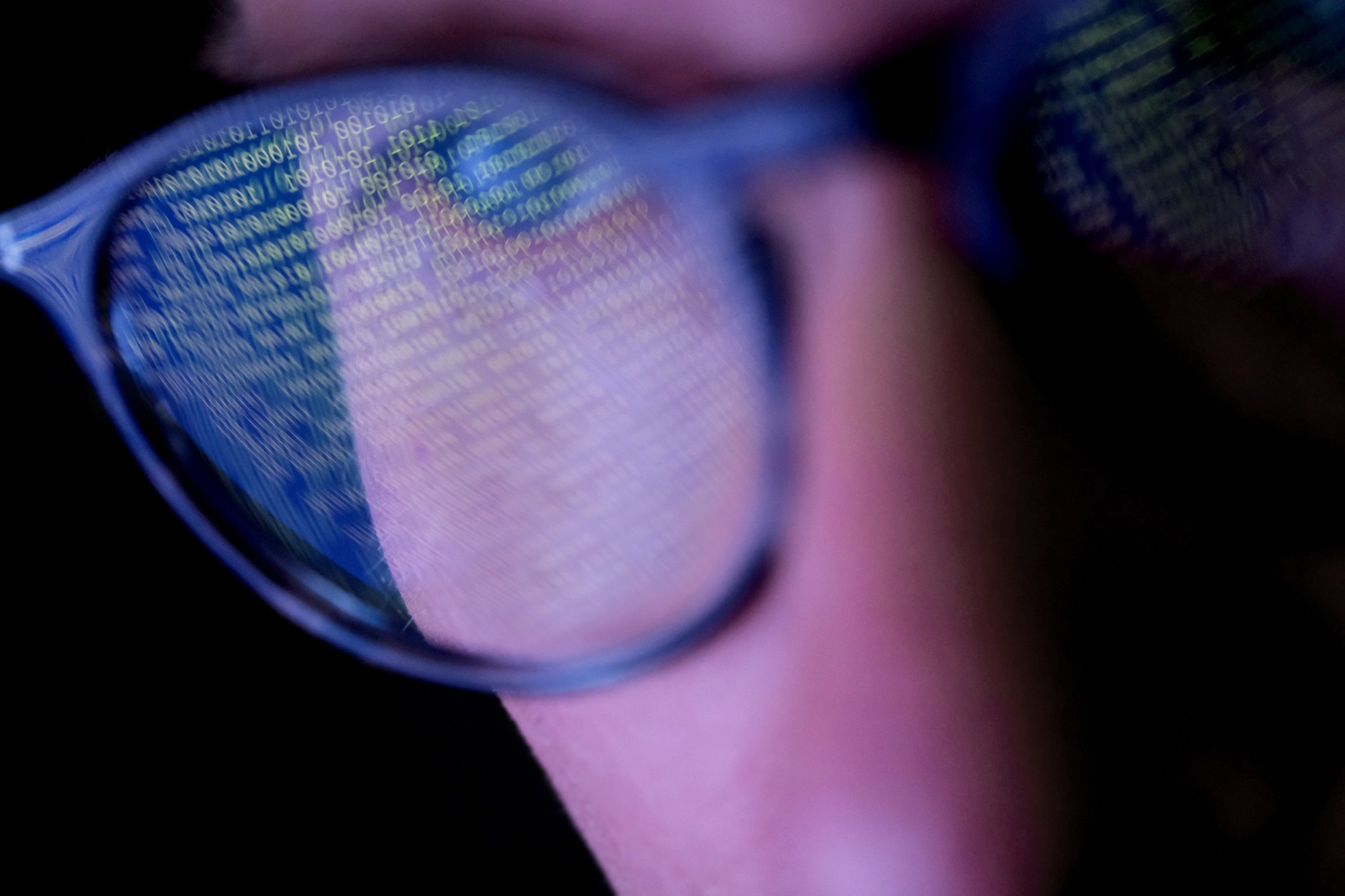 man in glasses looking at computer screen of data